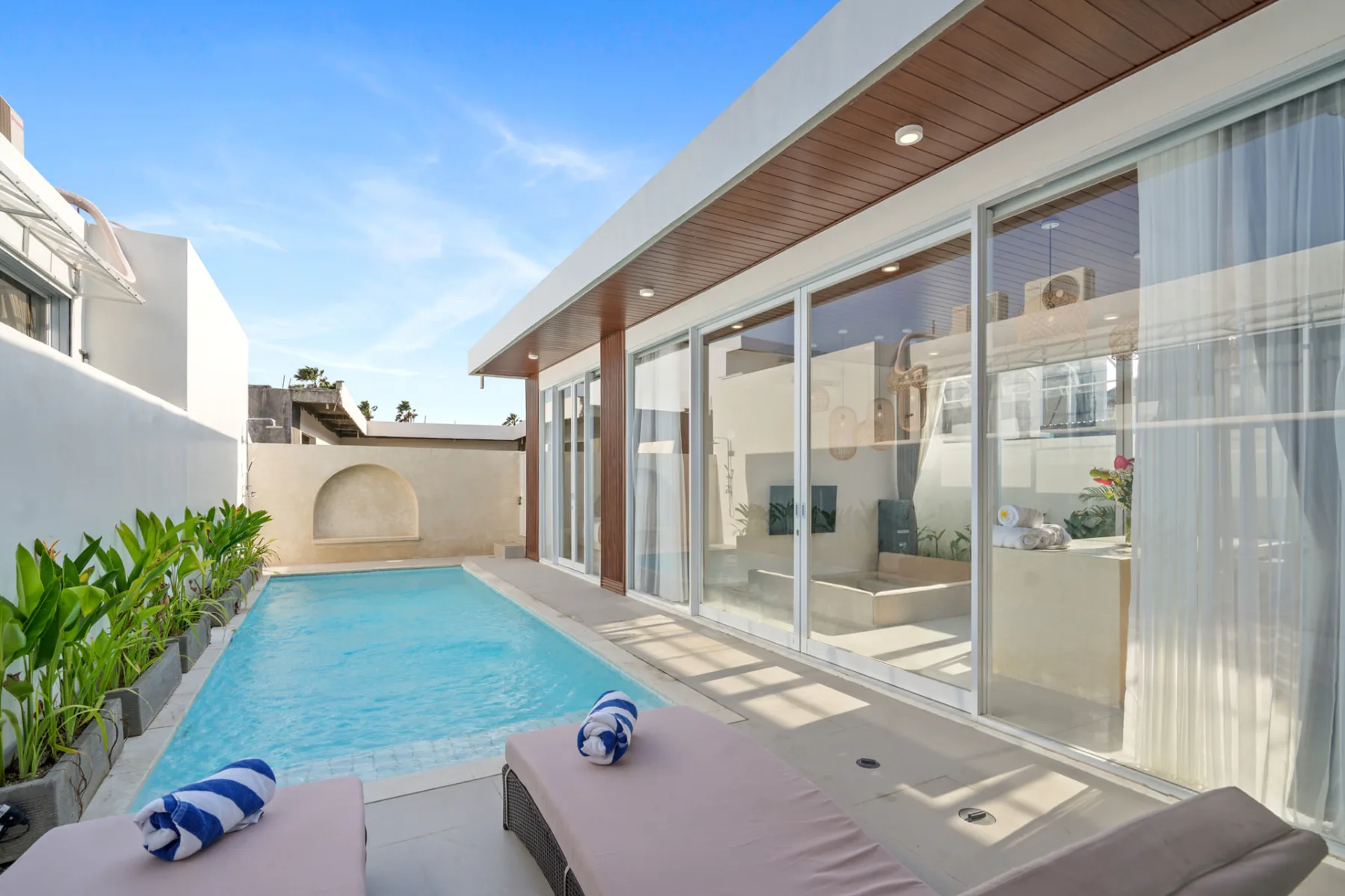 Private villa pool deck under high midday light